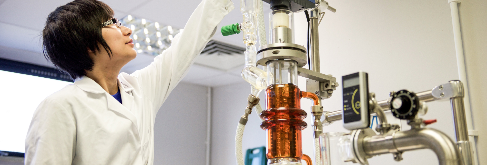 A lab worker attending to some equipment.